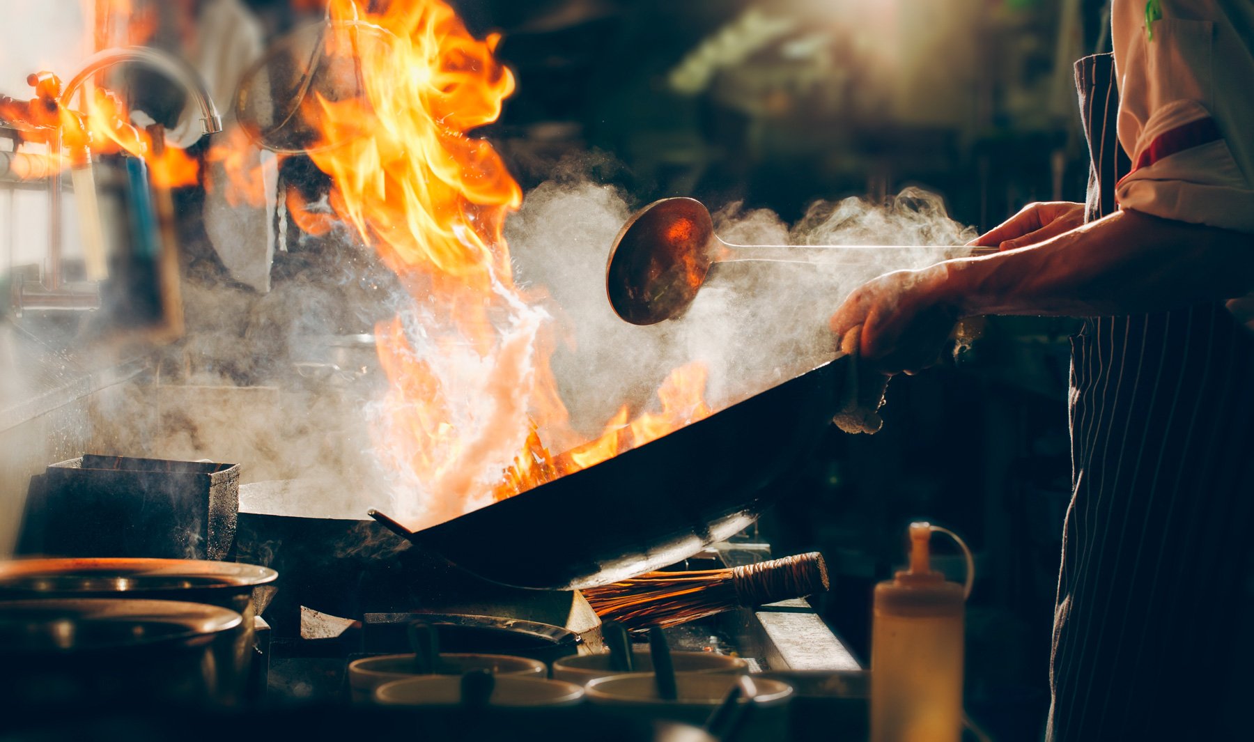 Sartén con flama grande, simbolizando los retos y presiones en la industria restaurantera durante 2022.